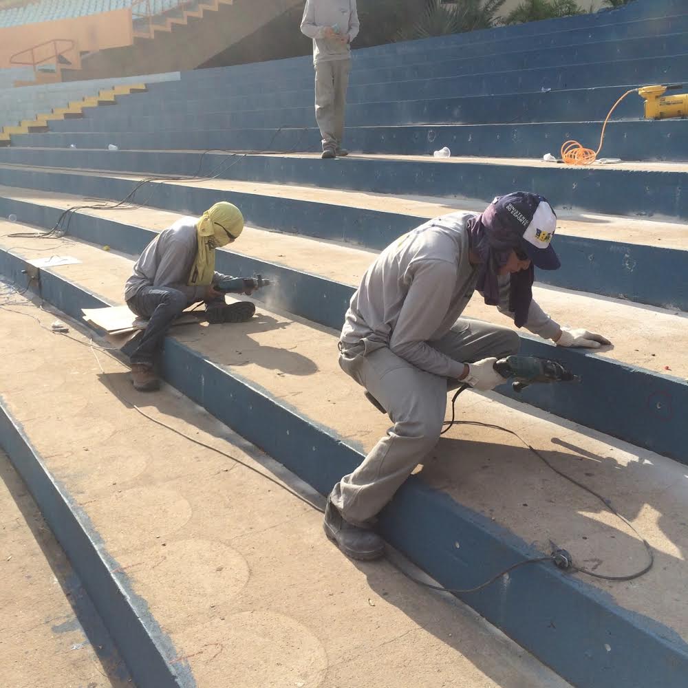 Trabalhadores trabalham instalando novas cadeiras no Serra Dourada