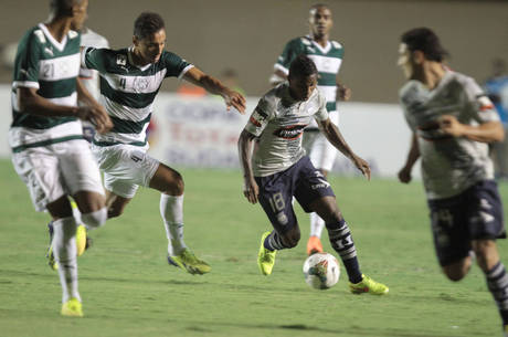 Jogadores do Goiás cercam atleta do Emelec em partida no Serra Dourada