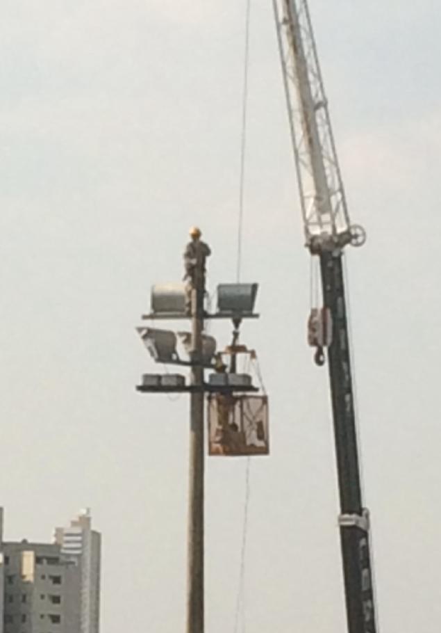 Homem trabalha no alto de torre de iluminação externa no Serra Dourada