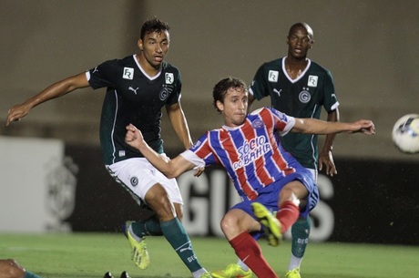 Dois jogadores do Goiás observam adversário tentar dominar a bola no Serra Dourada